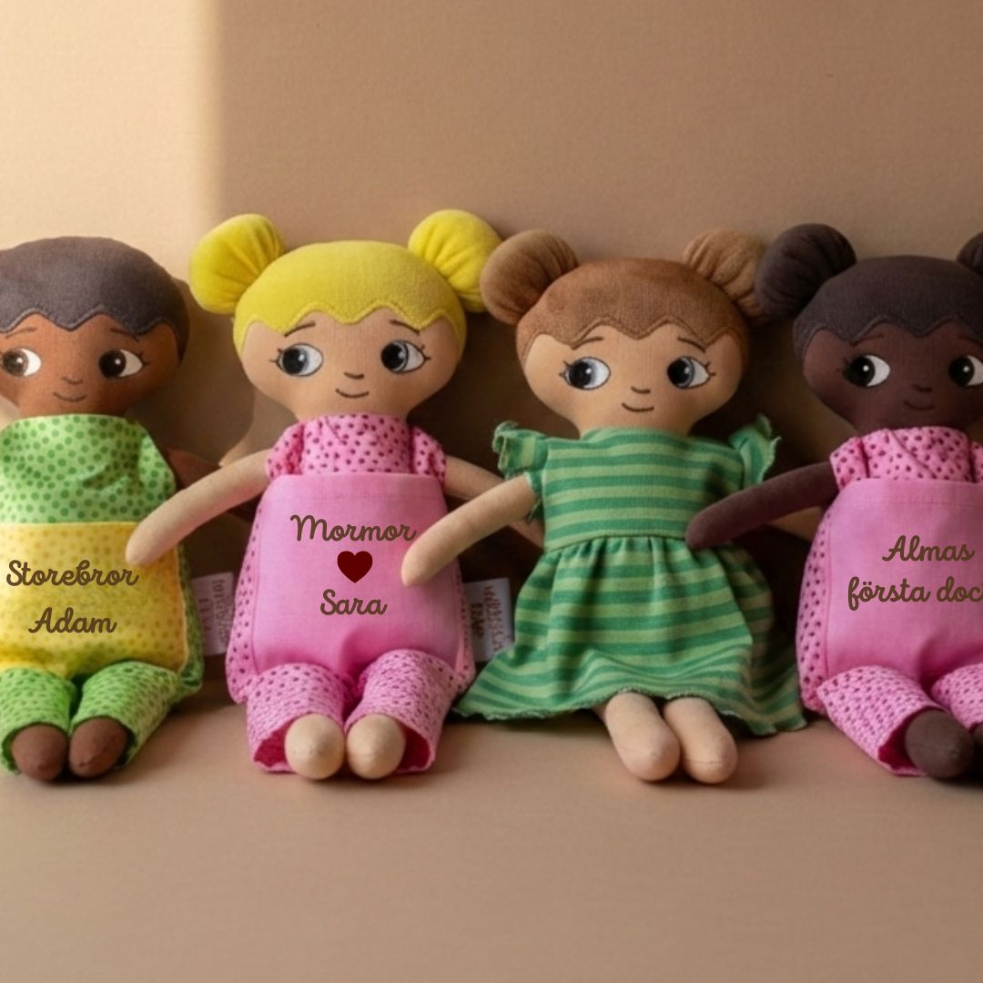 Fyra mjuka tygdockor med broderad personlig text från watoto arts. Dockorna har olika hårfärger och olika hudfärger för att representera olika barn.