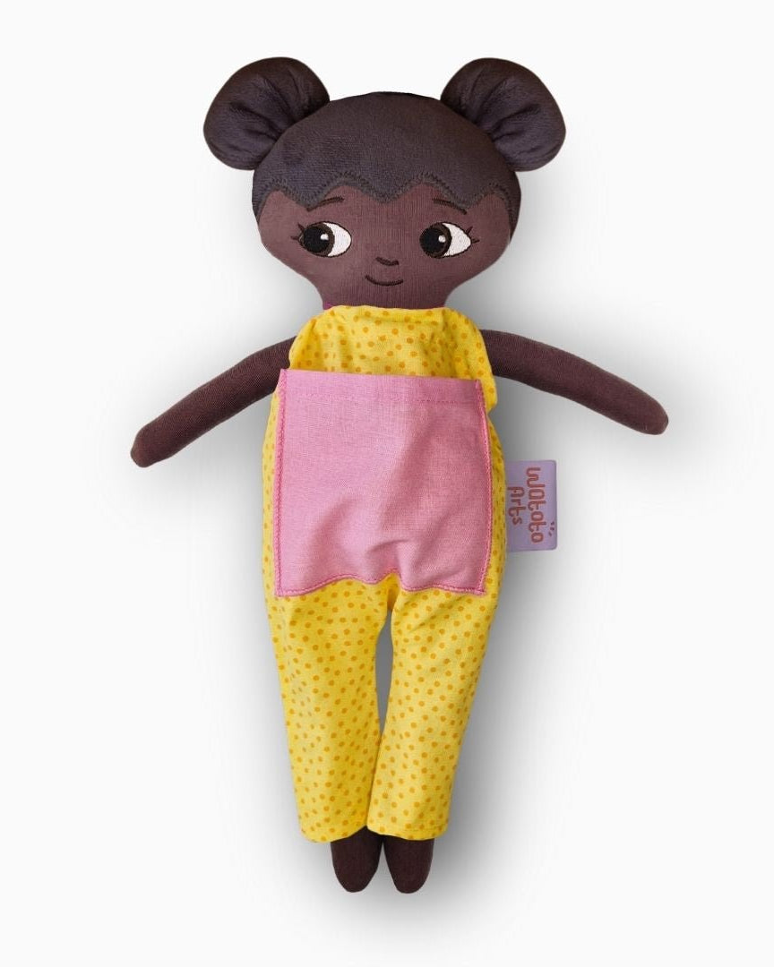 mjuk docka Amari i gul jumpsuit på vit bakgrund