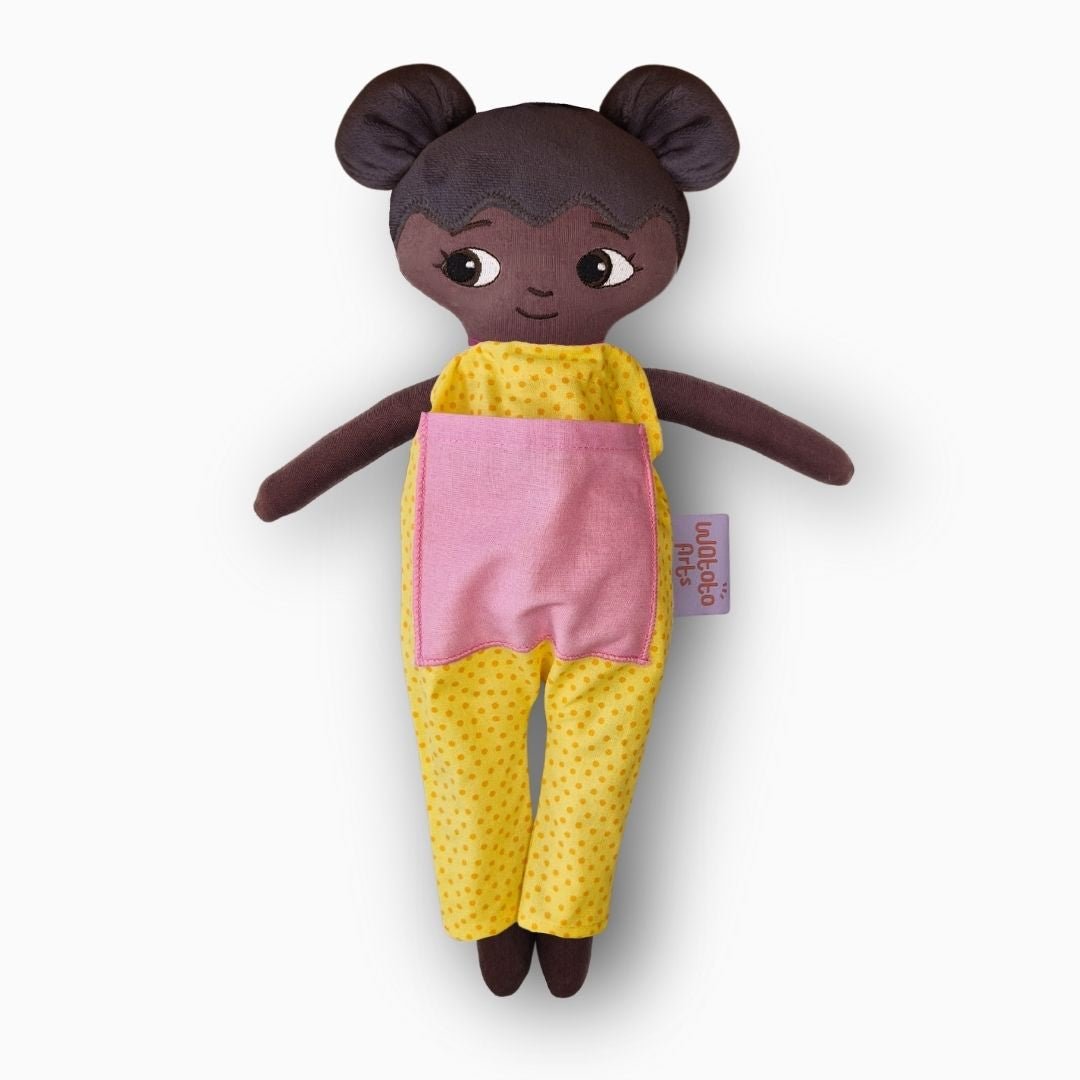 mjuk docka Amari i gul jumpsuit på vit bakgrund