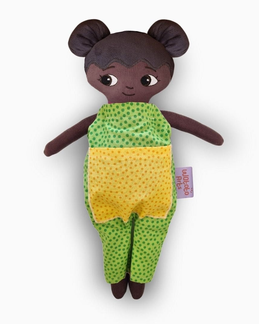 mjuk docka Amari i grön jumpsuit på vit bakgrund