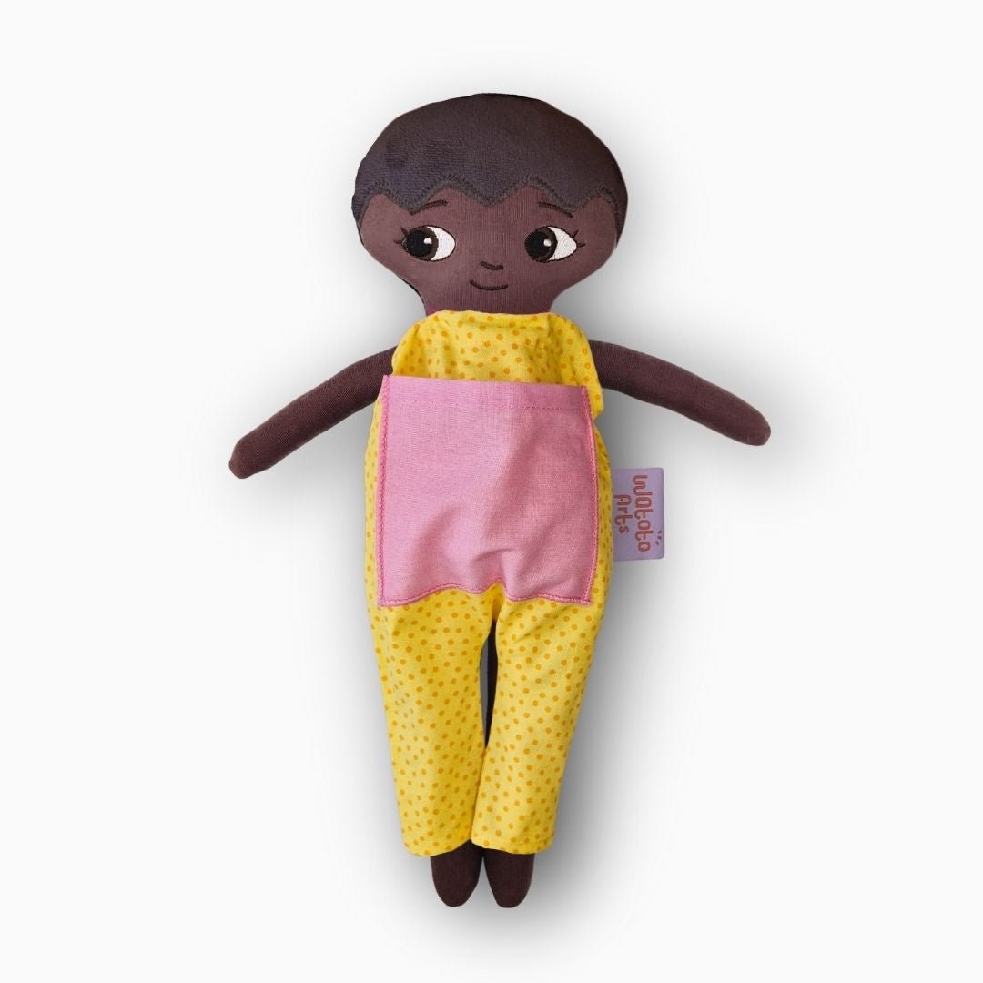 mjuk docka Liam i gul jumpsuit på vit bakgrund