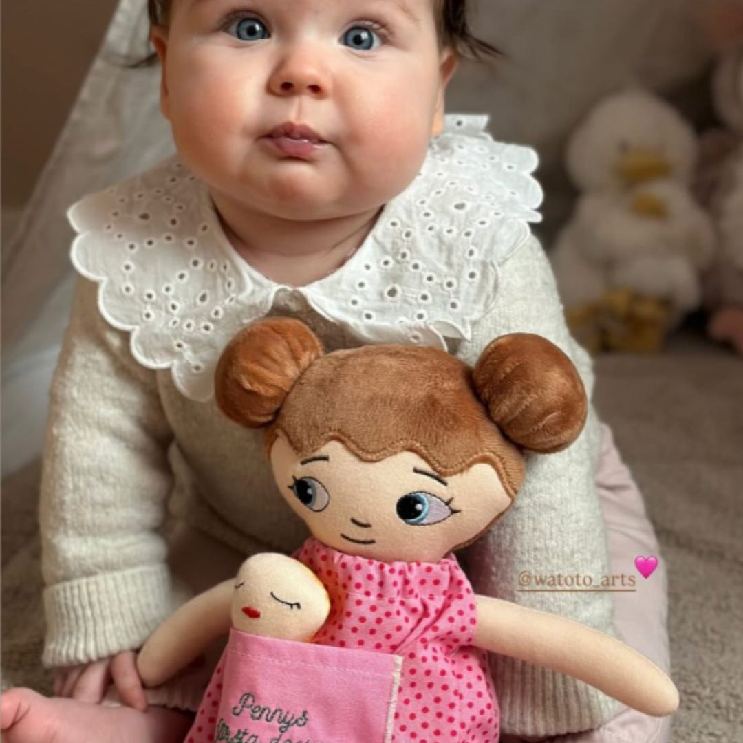 barn håller personlig tygdocka med namn sittandes i ett barnrum