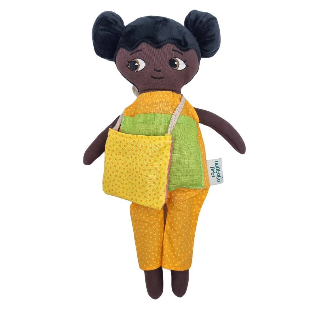 En watoto arts docka som bär på en dockväska