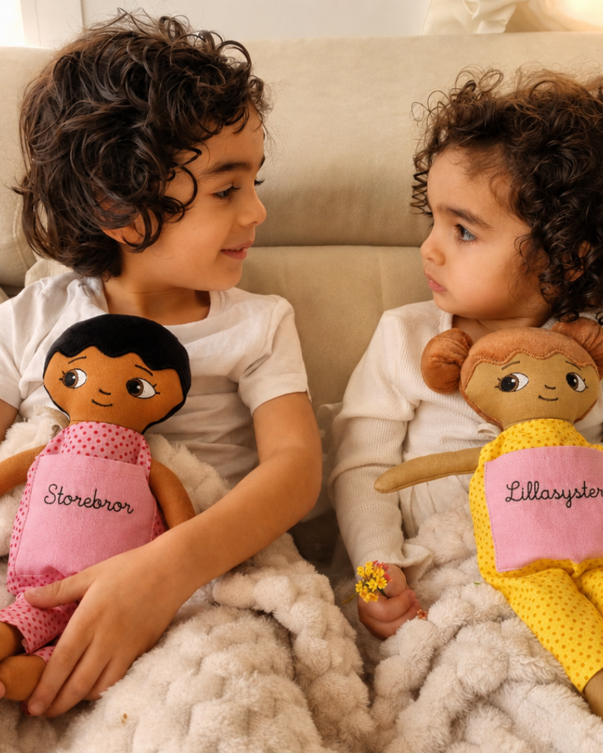 Two children with a soft doll each embroidered Storebror and lillasyster
