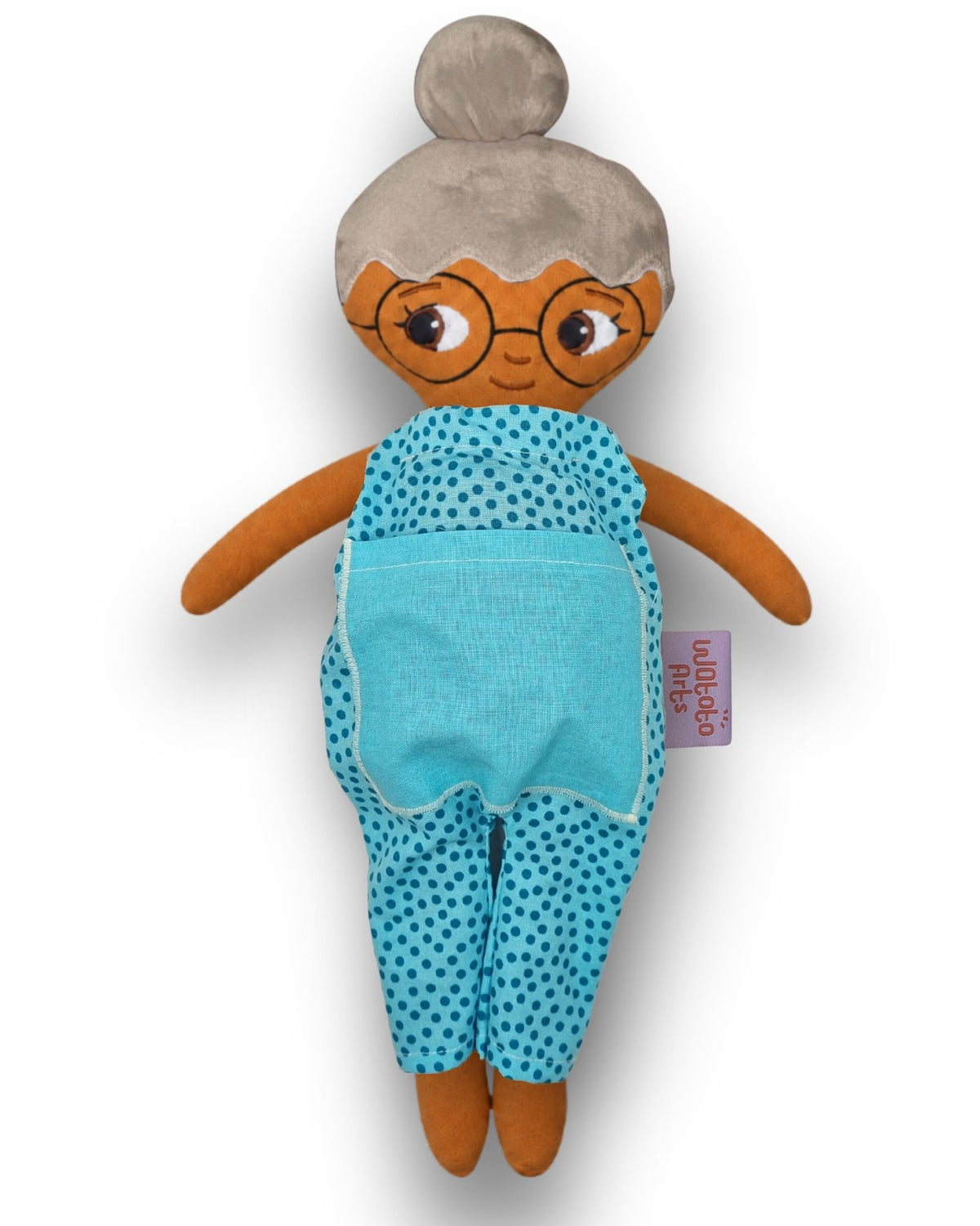 Mormor/farmor med grått hår i en hårknut, glasögon, brun hud och blå jumpsuit.