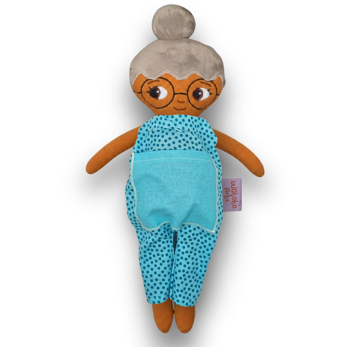 Mormor/farmor med grått hår i en hårknut, glasögon, brun hud och blå jumpsuit.