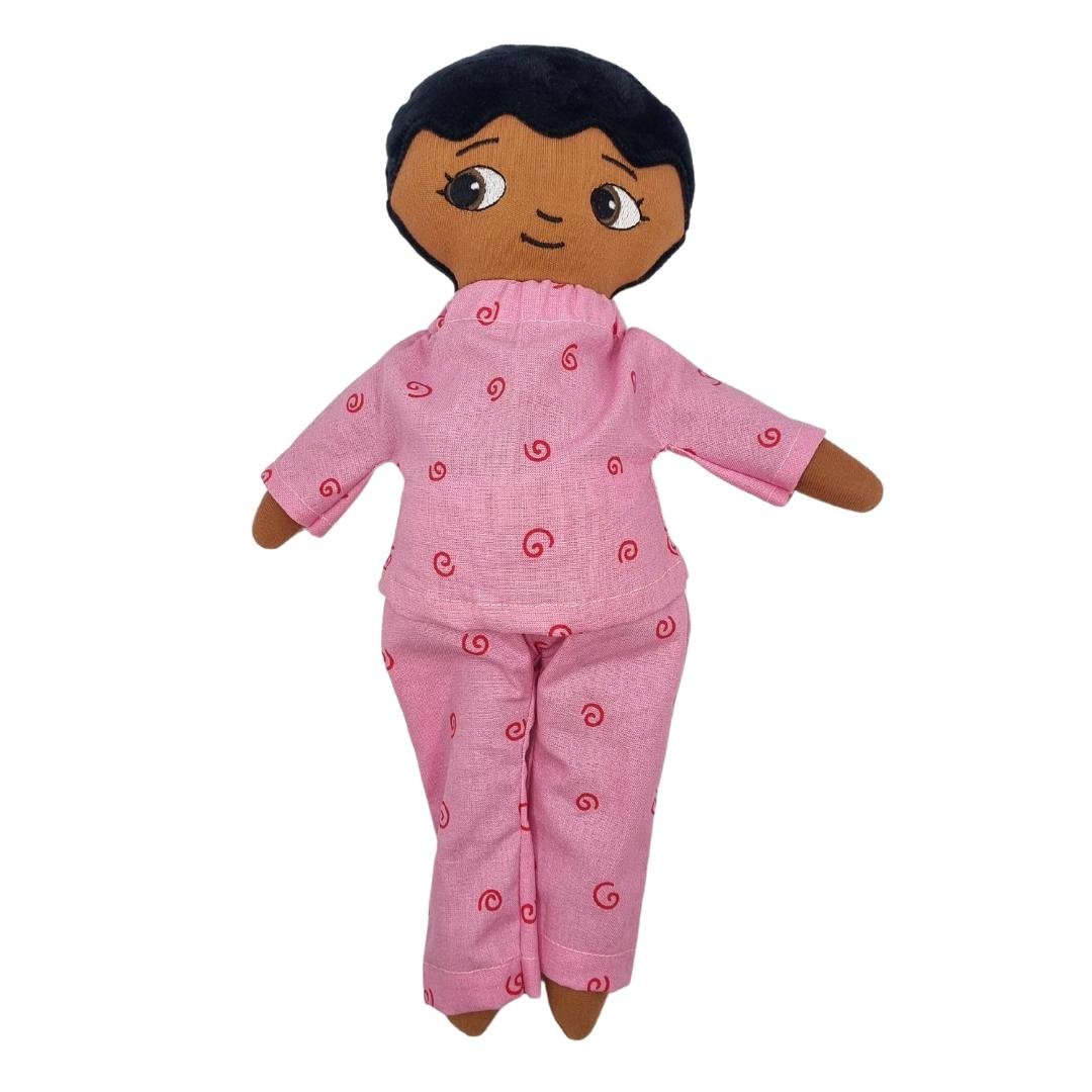 En Watoto Arts docka som bär en tvådelat blå pyjamas, rosa färg på pyjamasen