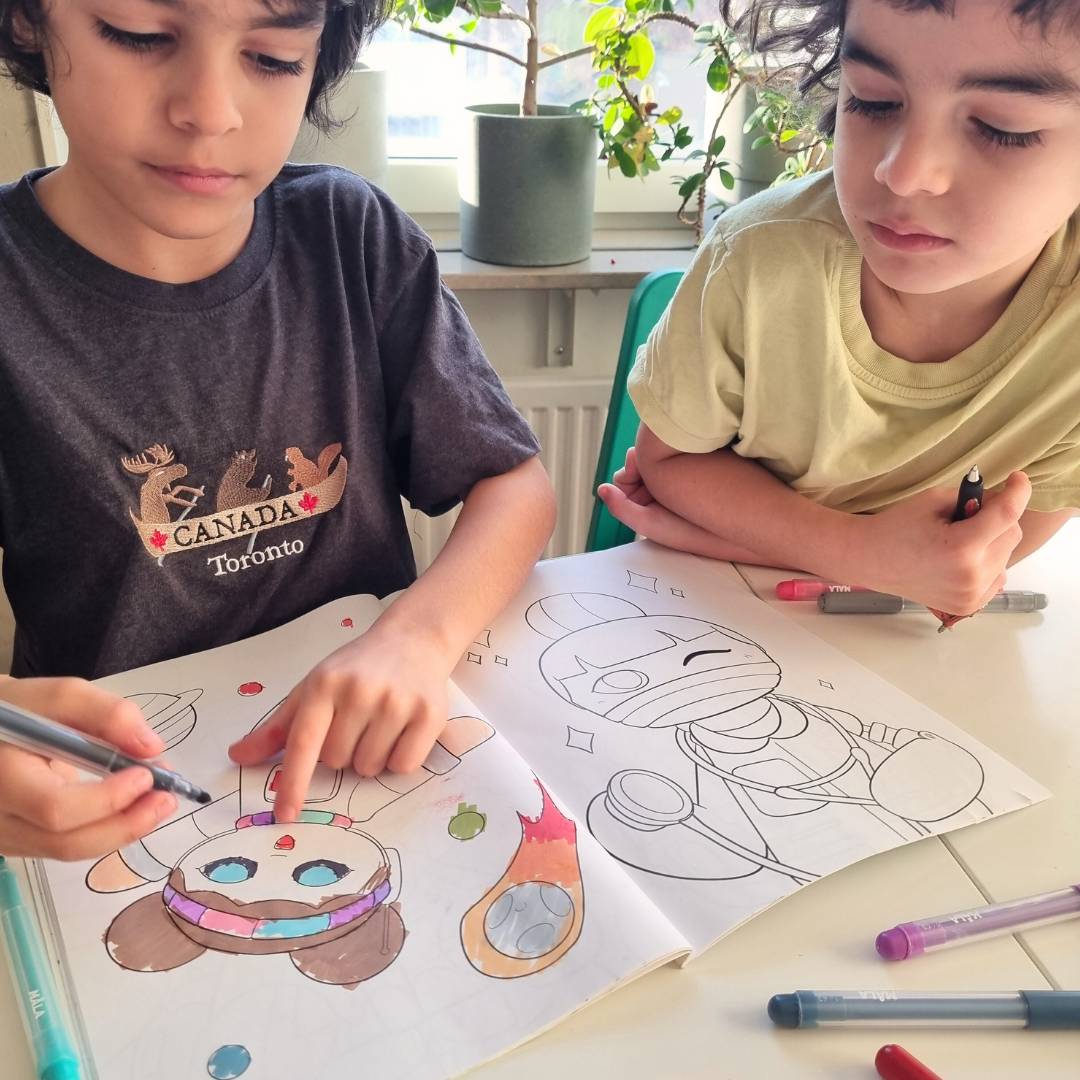 Två pojkar som målar i watoto arts målarbok