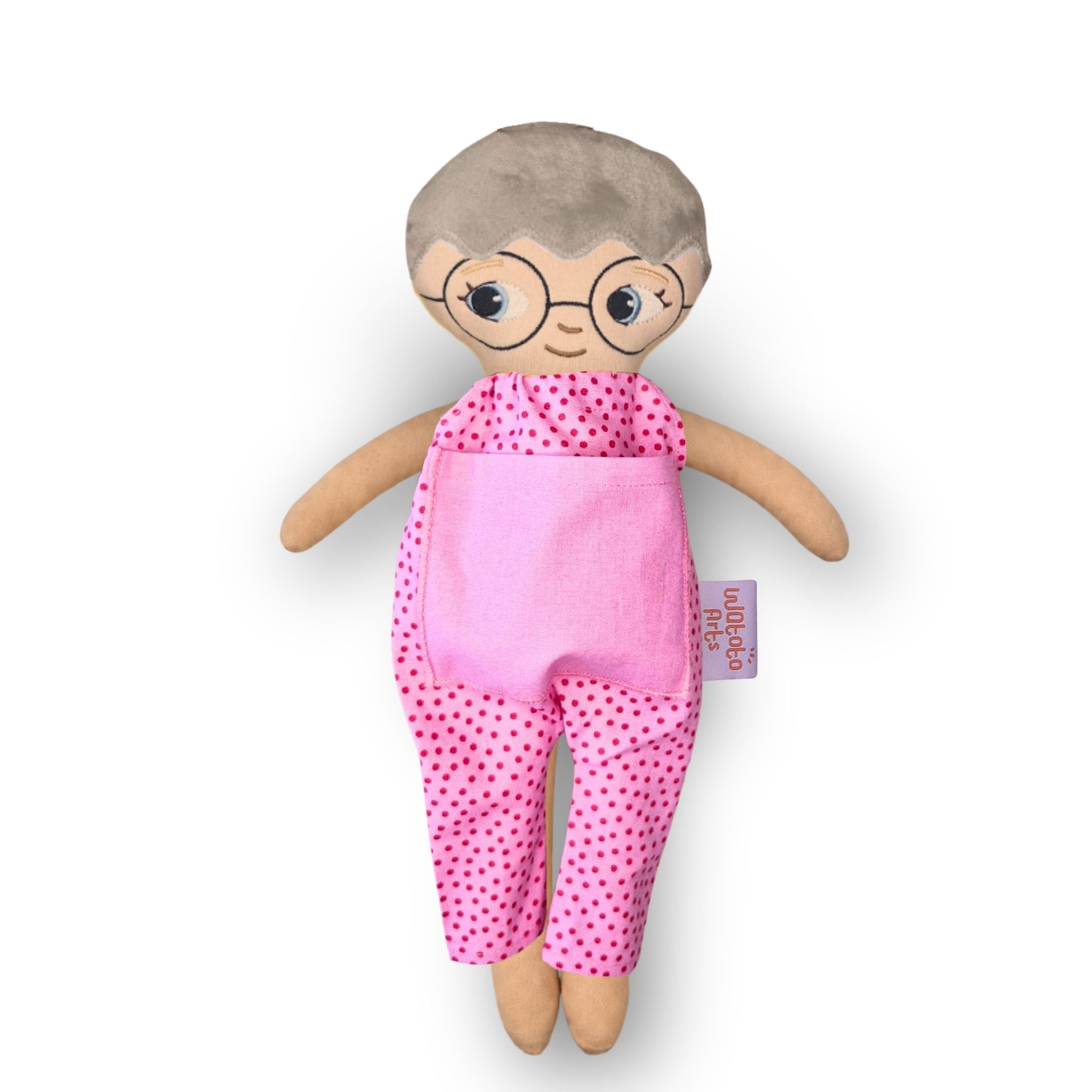 Docka med glasögon, vit hud, grått hår och blå ögon i rosa jumpsuit med rosa ficka