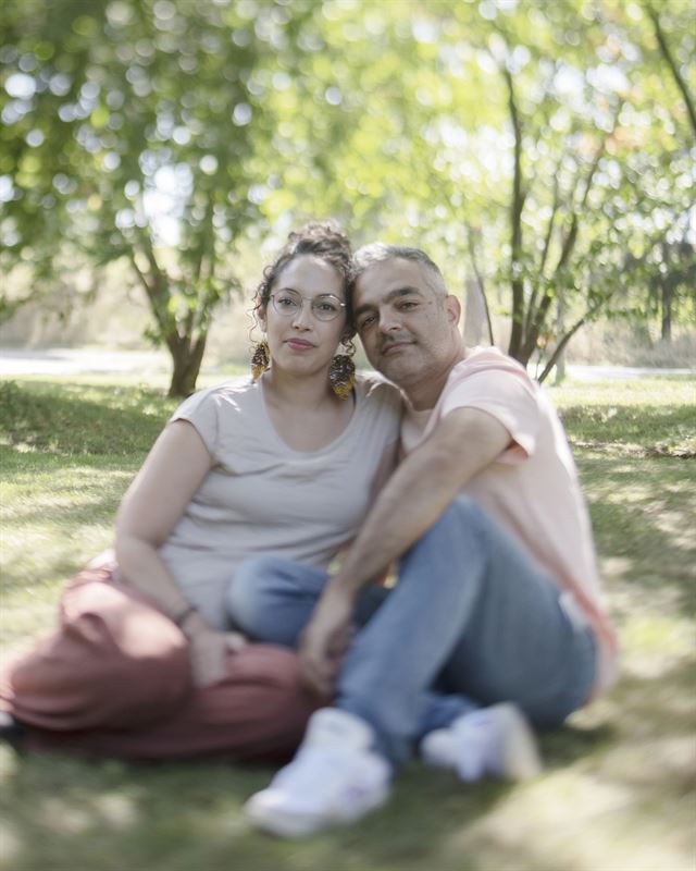 Fatma och Hamid sitter och håller om varandra i en park