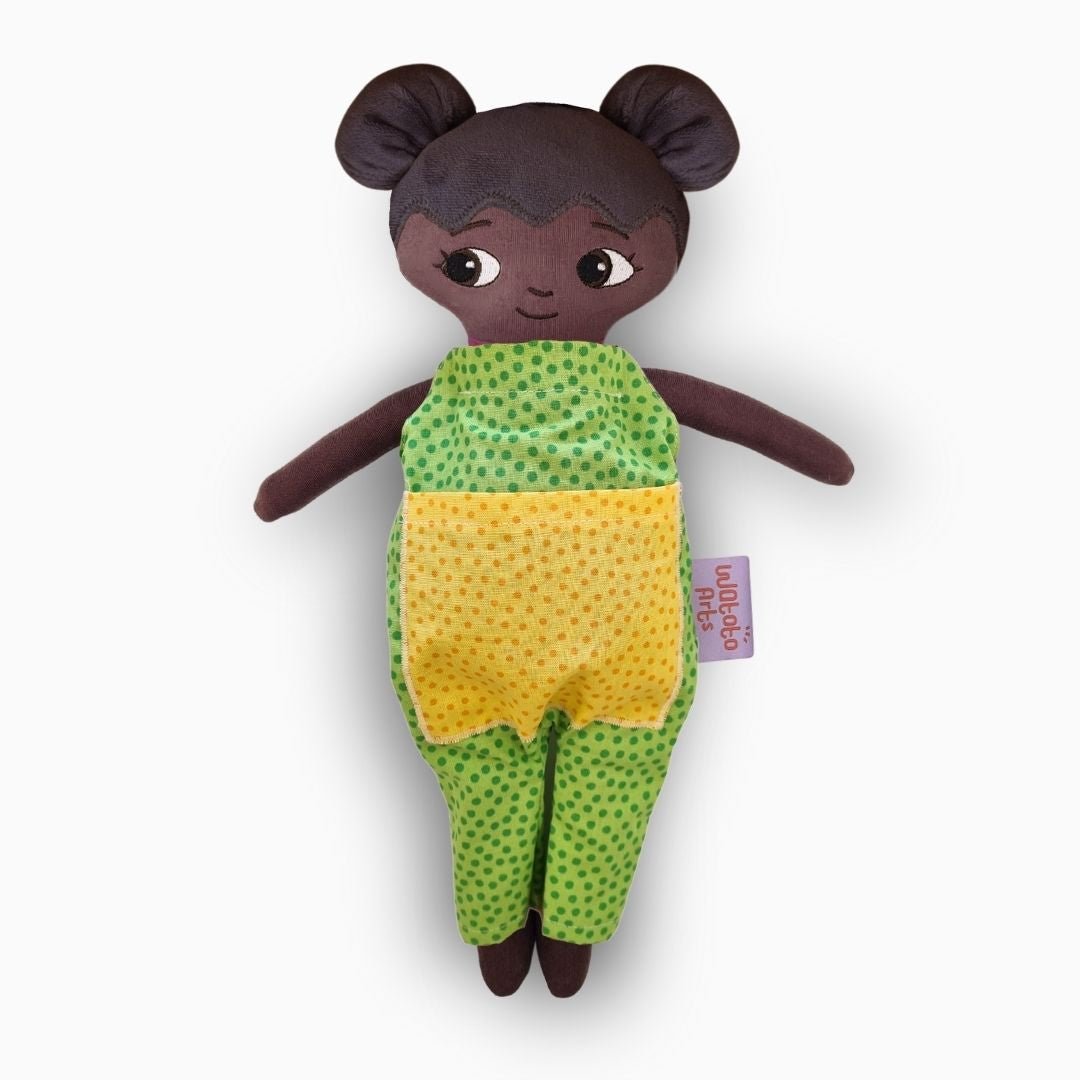 mjuk docka Amari i grön jumpsuit på vit bakgrund