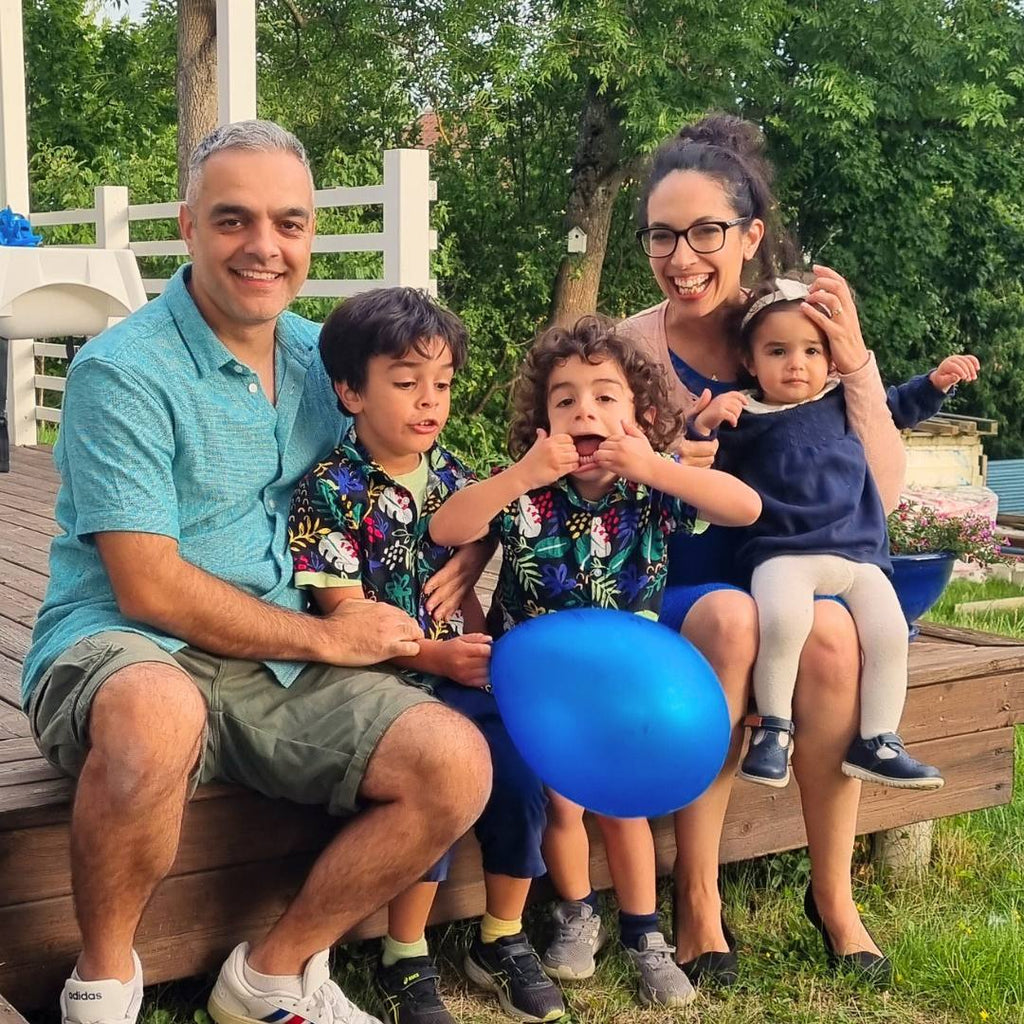 En familjebild på watoto arts familjen, mamma, pappa och tre barn ute i en park