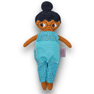 Fatima med glasögon, svart hår i en hårknut, brun hud och blå jumpsuit.