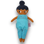 Fatima med glasögon, svart hår i en hårknut, brun hud och blå jumpsuit.