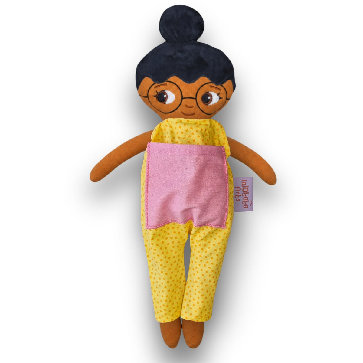 Fatima med glasögon, svart hår i en hårknut, brun hud och gul jumpsuit.