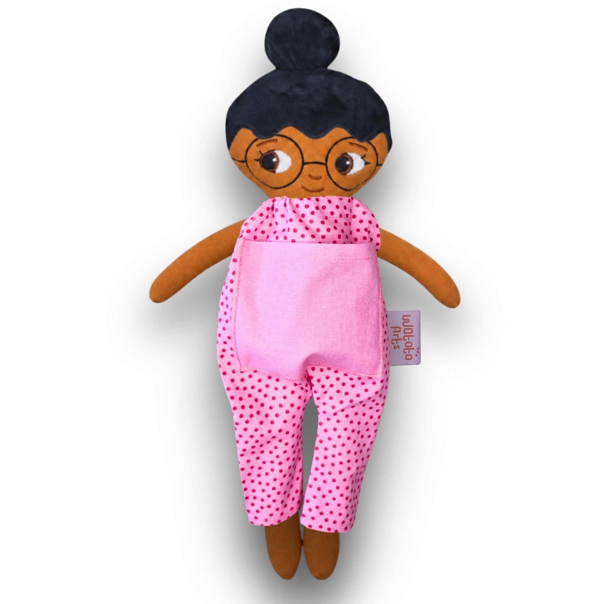 Fatima med glasögon, svart hår i en hårknut, brun hud och rosa jumpsuit.