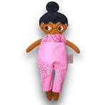 Fatima med glasögon, svart hår i en hårknut, brun hud och rosa jumpsuit.