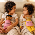 two children with a soft doll each embroidered Storebror and lillasyster