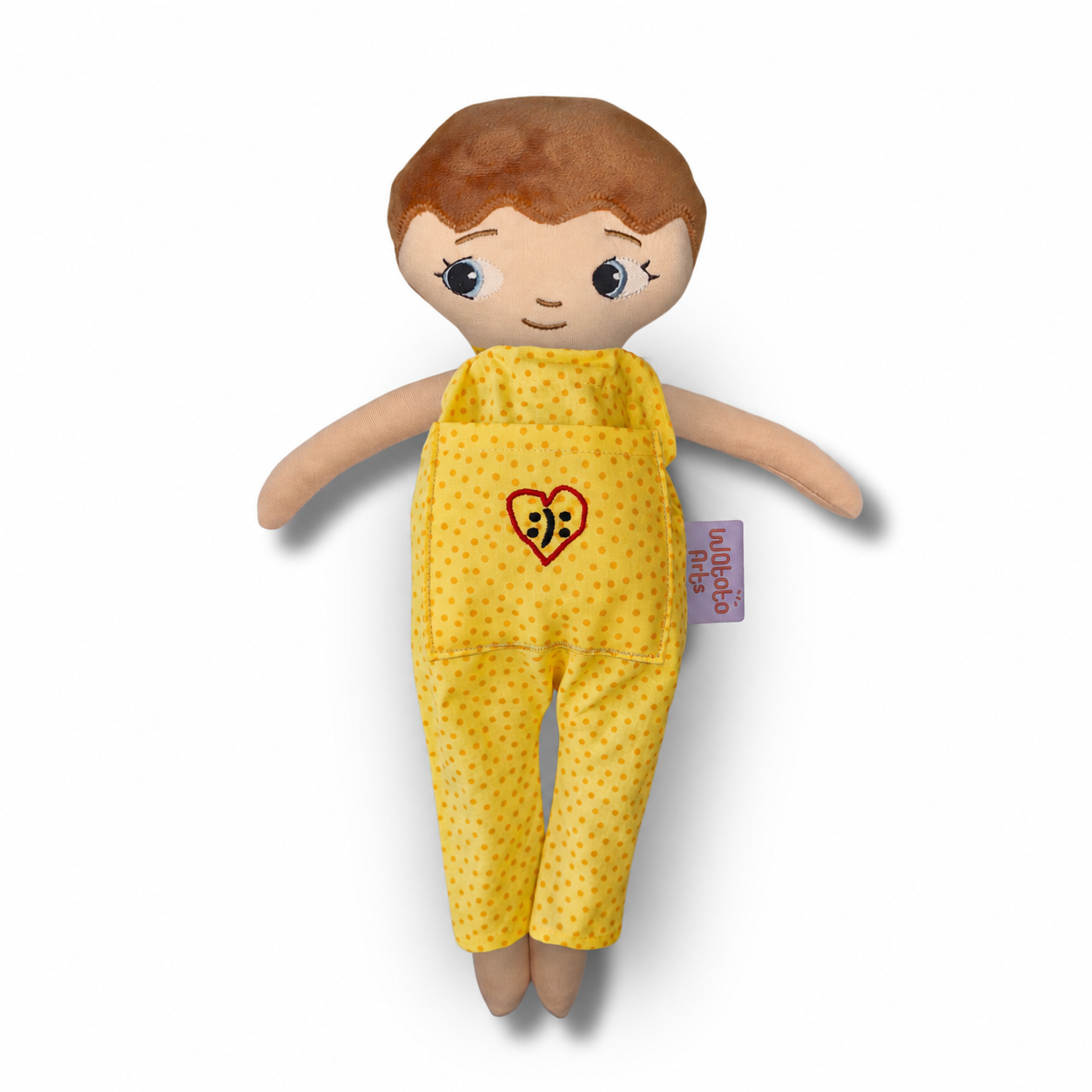 Mjuk docka Noa med ljus hud, kort brunt hår och gul prickig jumpsuit med ett broderat hjärta på fickan
