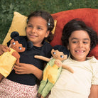 Två barn som leker med watoto arts normbrytande dockor, dockorna speglar barnens utseende. 