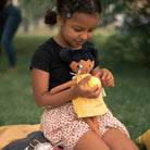 En flicka som leker med sin watoto arts docka som ser ut som henne