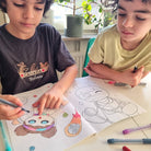 Två pojkar som målar i watoto arts målarbok